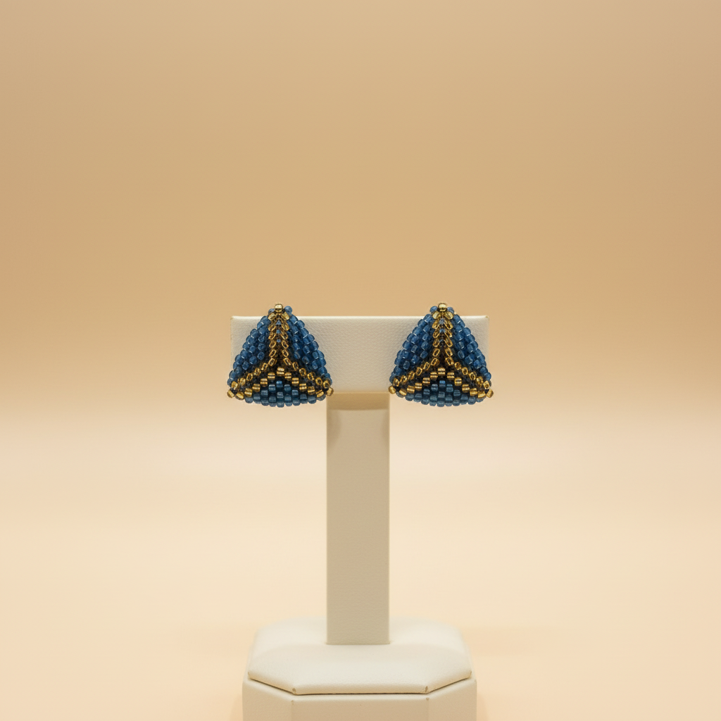 Blue-and-gold beaded earrings on an elegant jewelry stand