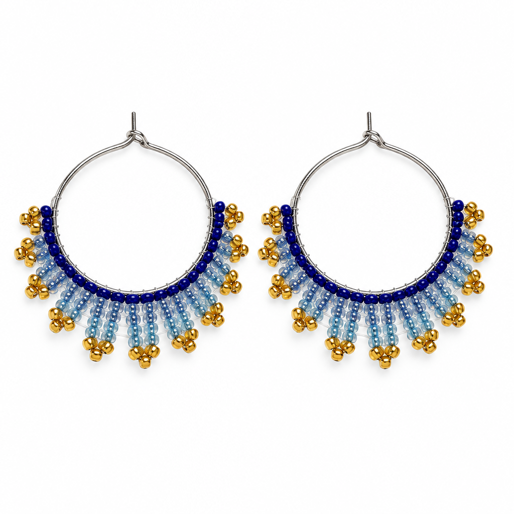 Pair of handmade beaded hoop earrings with royal blue, icy blue and gold seed beads on a white background