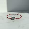 Red string colorful butterfly bracelet editorial product shot